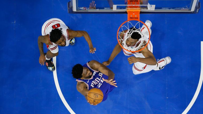 Philadelphia 76ers&#39; Joel Embiid goes up for a shot between Chicago Bulls&#39; Coby White and Wendell Carter Jr.