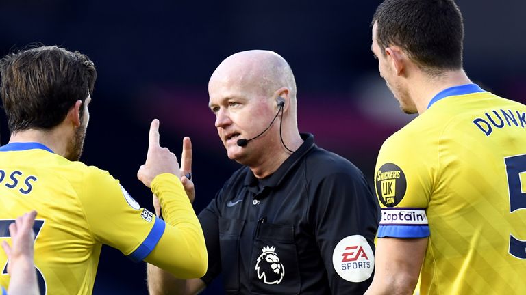 Players surround referee Lee Mason following confusion over Brighton's disallowed goal
