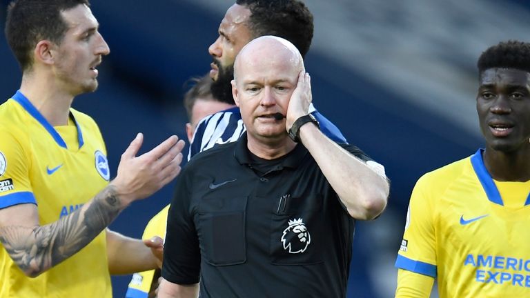 Referee Lee Mason confers with VAR over Lewis Dunk&#39;s disallowed free kick (AP)