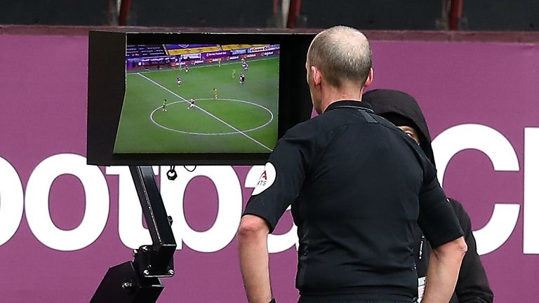 Mike Dean checks the monitor before sending off West Brom's Semi Ajayi