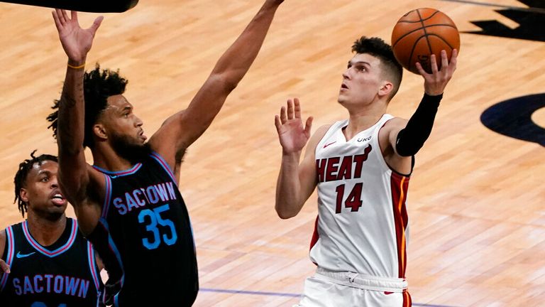 AP - Sacramento Kings forward Marvin Bagley III, front left left, challenges the shot of Miami Heat guard Tyler Herro