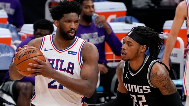 Philadelphia 76ers center Joel Embiid, left, looks to pass against Sacramento Kings center Richaun Holmes, right, during the second half of an NBA basketball game in Sacramento, Calif., Tuesday, Feb. 9, 2021. The 76ers won 119-111.