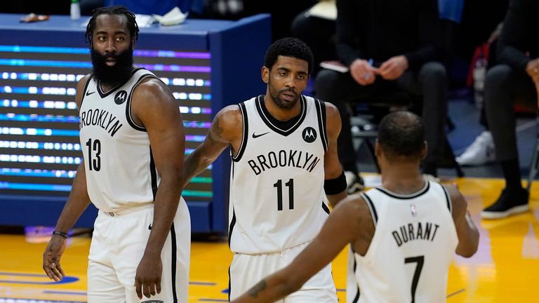 Brooklyn Nets guard Kyrie Irving, middle, gathers with guard James Harden (13) and forward Kevin Durant (7) during the second half of an NBA basketball game against the Golden State Warriors in San Francisco, Saturday, Feb. 13, 2021. (AP Photo/Jeff Chiu)
