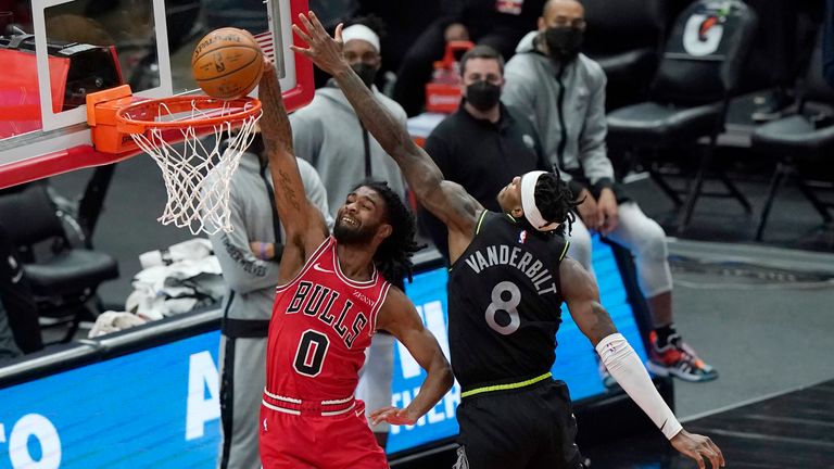 Chicago Bulls guard Coby White, left, dunks against Minnesota Timberwolves forward Jarred Vanderbilt during overtime of an NBA basketball game in Chicago, Wednesday, Feb. 24, 2021. The Bulls won 133-126 in overtime. (AP Photo/Nam Y. Huh)


