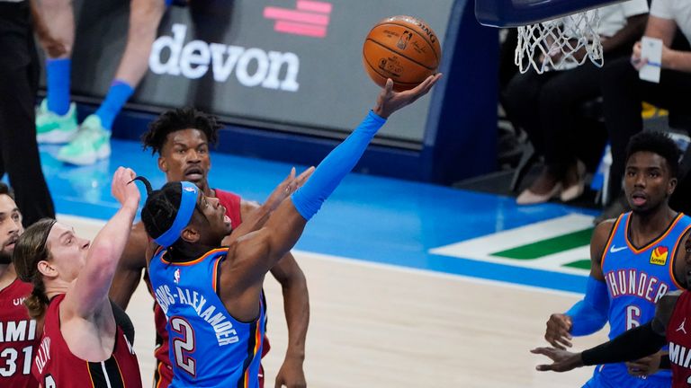 Oklahoma City Thunder guard Shai Gilgeous-Alexander (2) shoots in front of Miami Heat forward Kelly Olynyk, left, and forward Jimmy Butler, rear, in the first half of an NBA basketball game Monday, Feb. 22, 2021, in Oklahoma City.