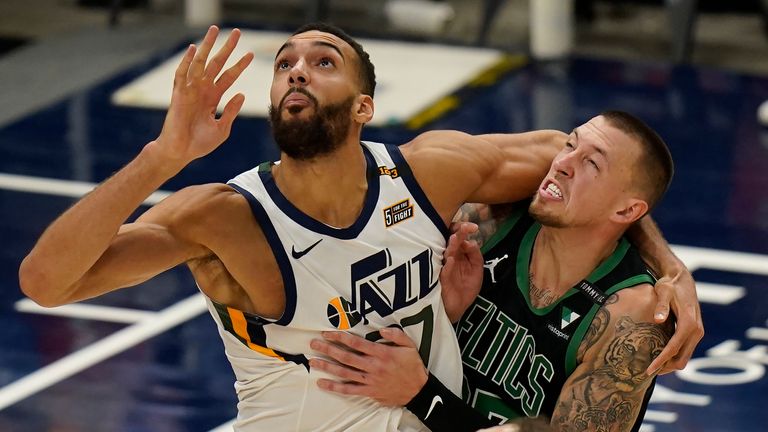 Utah Jazz center Rudy Gobert, left, and Boston Celtics center Daniel Theis, right, battle for position under the boards in the second half during an NBA basketball game Tuesday, Feb. 9, 2021, in Salt Lake City.