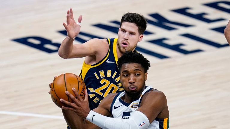 Utah Jazz guard Donovan Mitchell (45) makes a pass in front of Indiana Pacers forward Doug McDermott (20) during the first half of an NBA basketball game in Indianapolis, Sunday, Feb. 7, 2021. (AP Photo/Michael Conroy)



