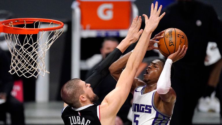 Sacramento Kings guard De&#39;Aaron Fox, right, shoots as Los Angeles Clippers center Ivica Zubac defends during the second half of an NBA basketball game Sunday, Feb. 7, 2021, in Los Angeles. (AP Photo/Mark J. Terrill)


