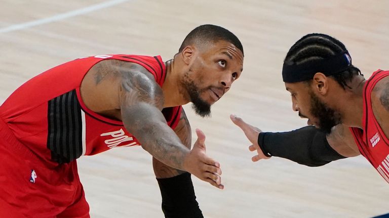 Portland Trail Blazers guard Damian Lillard, left, is congratulated by teammate Carmelo Anthony, right, in the final seconds of an NBA basketball game against the Oklahoma City Thunder, Tuesday, Feb. 16, 2021, in Oklahoma City.