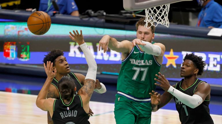 Dallas Mavericks guard Luka Doncic (77) makes a pass inside past Minnesota Timberwolves guard Ricky Rubio (9) and Minnesota Timberwolves forward Anthony Edwards (1) during the first half of an NBA basketball game, Monday, Feb. 8, 2021, in Dallas. (AP Photo/Ron Jenkins)


