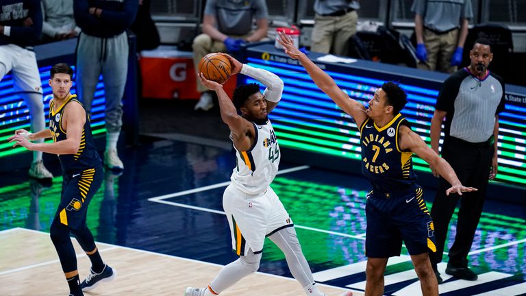 Utah Jazz guard Donovan Mitchell (45) makes a pass over Indiana Pacers guard Malcolm Brogdon (7) during the second half of an NBA basketball game in Indianapolis, Sunday, Feb. 7, 2021. (AP Photo/Michael Conroy)


