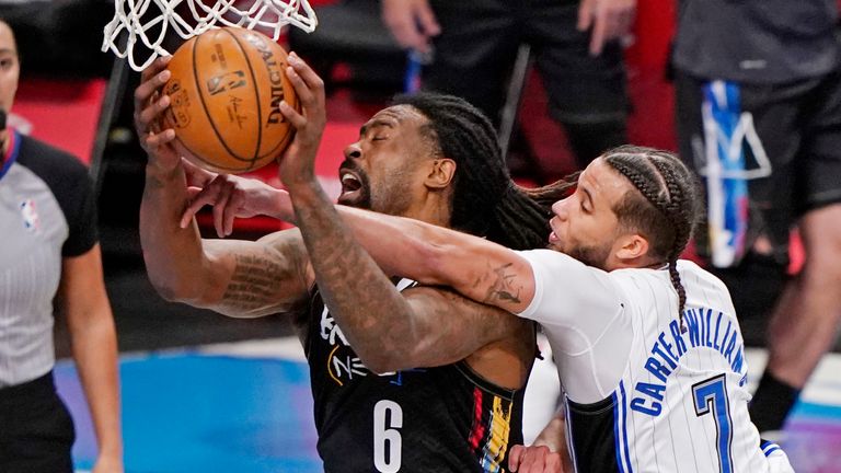 Orlando Magic guard Michael Carter-Williams (7) gets his hand caught as Brooklyn Nets center DeAndre Jordan (6) goes up to shoot beneath the basket during the third quarter of an NBA basketball game, Thursday, Feb. 25, 2021, in New York.