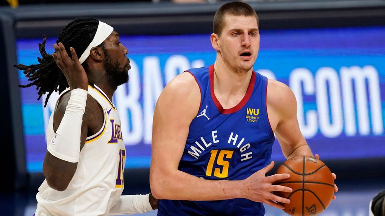 Denver Nuggets center Nikola Jokic, right, looks to pass the ball as Los Angeles Lakers center Montrezl Harrell defends in the first half of an NBA basketball game Sunday, Feb. 14, 2021, in Denver. (AP Photo/David Zalubowski).............