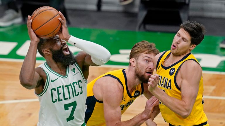 Boston Celtics guard Jaylen Brown (7) shoots against Indiana Pacers forward Domantas Sabonis, middle, and forward Doug McDermott, right, in the second half of an NBA basketball game, Friday, Feb. 26, 2021, in Boston. (AP Photo/Elise Amendola)


