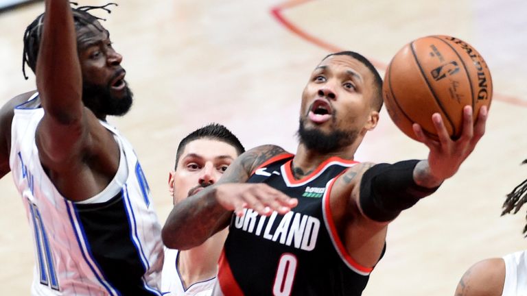 Portland Trail Blazers guard Damian Lillard drives to the basket on Orlando Magic forward James Ennis III, left, during the second half of an NBA basketball game in Portland, Ore., Tuesday, Feb. 9, 2021. The Blazers won 106-97. 