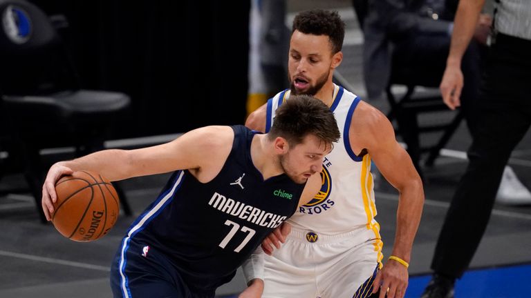 Dallas Mavericks&#39; Luka Doncic (77) works against Golden State Warriors&#39; Stephen Curry, right, in the second half of an NBA basketball game in Dallas, Saturday, Feb. 6, 2021. (AP Photo/Tony Gutierrez)


