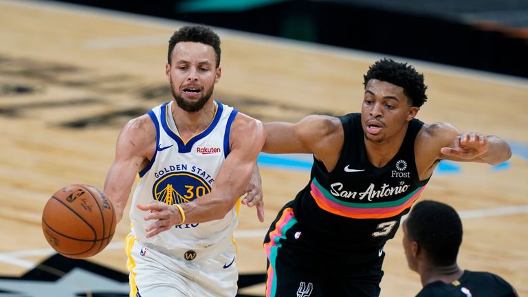 Golden State Warriors guard Stephen Curry (30) drives past San Antonio Spurs forward Keldon Johnson (3) during the second half of an NBA basketball game in San Antonio, Tuesday, Feb. 9, 2021. 