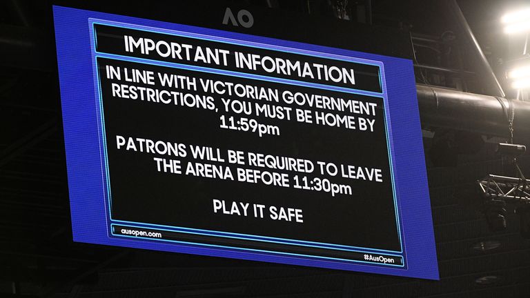 An electronic signboard on Rod Laver Arena reminds patrons about the lockdown start time during the third round match between Serbia's Novak Djokovic and United States' Talyor Fritz at the Australian Open tennis championship in Melbourne, Australia, Friday, Feb. 12, 2021. Melbourne, Australia's second-largest city, will begin its third lockdown on Friday due to a rapidly spreading COVID-19 cluster centered on hotel quarantine.(AP Photo/Andy Brownbill)