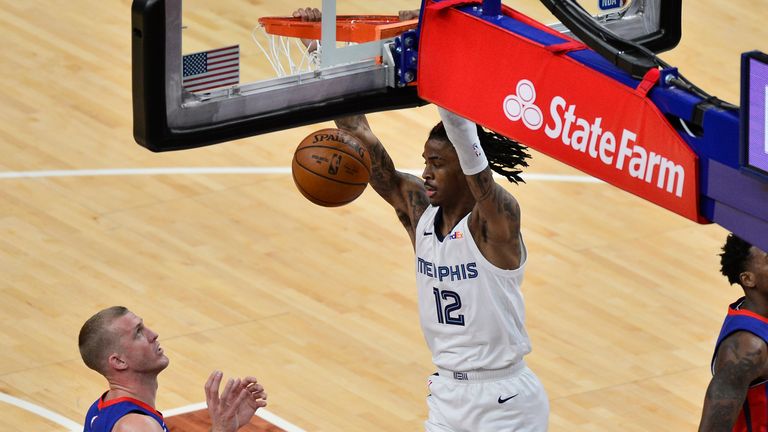 Memphis Grizzlies guard Ja Morant dunks next to Detroit Pistons center Mason Plumlee