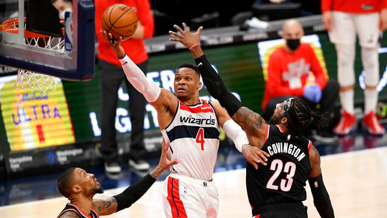 AP - Washington Wizards guard Russell Westbrook (4) goes to the basket between Portland Trail Blazers forward Robert Covington (23) and guard Damian Lillard,