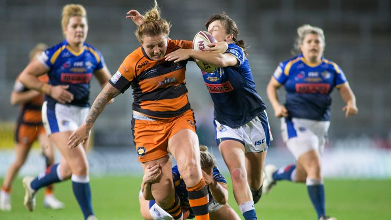 Rhiannion Marshall of Castleford is tackled by Charlotte Booth and Hannah Butcher of Leeds in the 2019 Grand Final