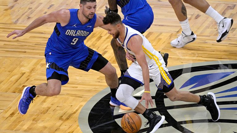 Golden State Warriors guard Stephen Curry drives to the basket in front of center Nikola Vucevic