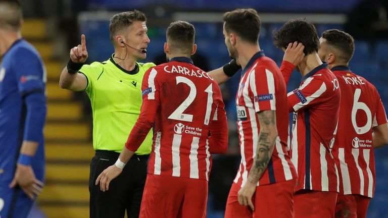 Atletico players surround referee Daniele Orsato following the penalty incident