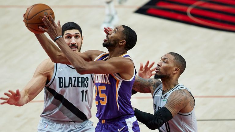 Phoenix Suns forward Mikal Bridges shoots between Portland Trail Blazers center Enes Kanter and guard Damian Lillard
