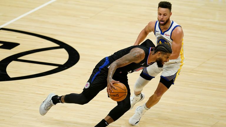 Los Angeles Clippers guard Paul George dribbles past Golden State Warriors guard Stephen Curry