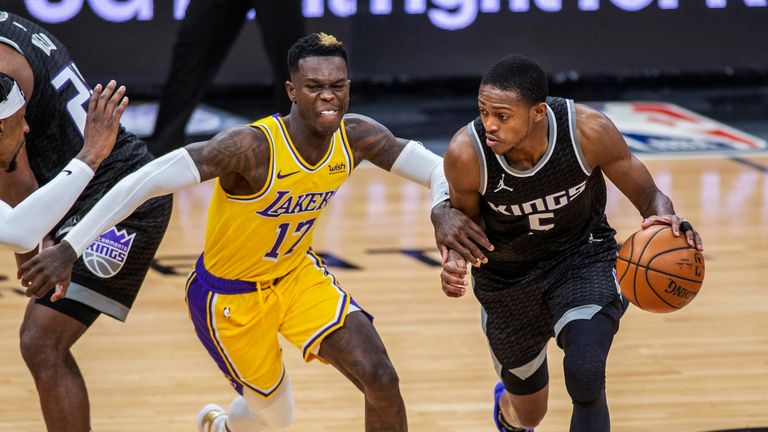 Sacramento Kings guard De&#39;Aaron Fox drives to the basket as he&#39;s defended by Los Angeles Lakers guard Dennis Schroder