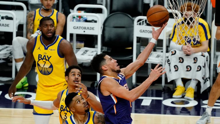Phoenix Suns guard Devin Booker drives past Golden State Warriors guard Jordan Poole and forward Kent Bazemore