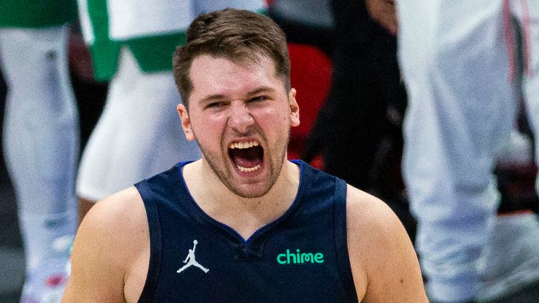 Dallas Mavericks guard Luka Doncic (77) celebrates with teammate James Johnson (16) after making a 3-point basket during the second half of an NBA basketball game against the Boston Celtics in Dallas, Tuesday, Feb. 23, 2021.