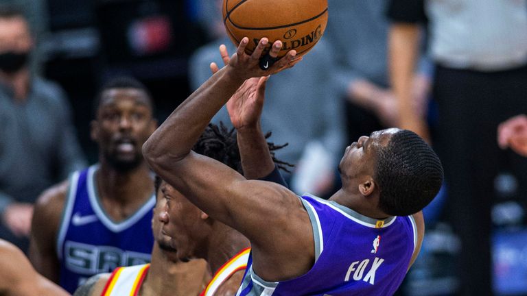 Sacramento Kings guard De'Aaron Fox (5) is fouled on his way to the basket by Atlanta Hawks forward De'Andre Hunter (12) in the fourth quarter of an NBA basketball game in Sacramento, Calif., Wednesday March 24, 2021. The Sacramento Kings won 110-108. (AP Photo/Hector Amezcua)