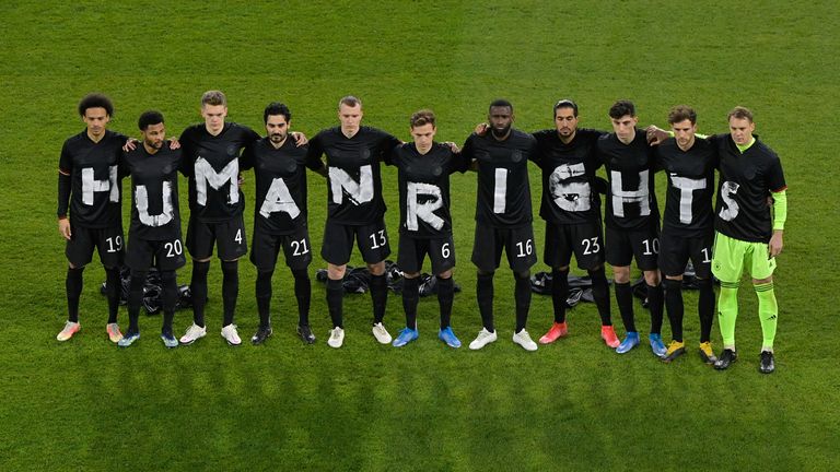 25 March 2021, North Rhine-Westphalia, Duisburg: Football: World Cup Qualification Europe, Germany - Iceland, Group Stage, Group J, Matchday 1 at Schauinsland-Reisen-Arena. The players of the German national team stand together and form the lettering "Human Rights". 