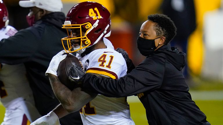 Jennifer King, right, works with Washington Football Team running back J.D. McKissic before the team's NFL wildcard matchup with the Tampa Bay Buccaneers (AP Photo/Julio Cortez)