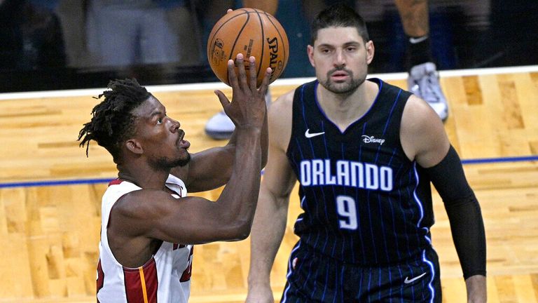 AP - Miami Heat forward Jimmy Butler, left, goes up to shoot in front of Orlando Magic center Nikola Vucevic (9)