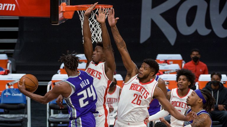 Sacramento Kings guard Buddy Hield drives to the basket as Houston Rockets forward Jae&#39;Sean Tate and Rockets center Justin Patton defend
