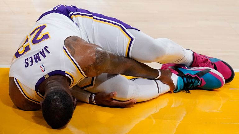 Los Angeles Lakers' LeBron James holds his ankle after going down with an injury during the first half against the Atlanta Hawks. (AP Photo/Marcio Jose Sanchez)
