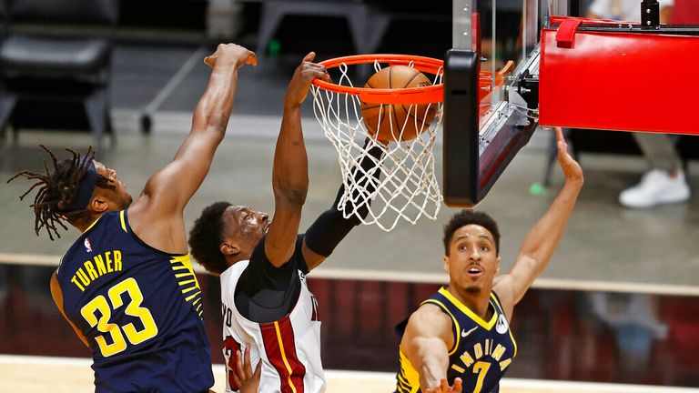 AP - Miami Heat center Bam Adebayo (13) scores between Indiana Pacers center Myles Turner (33) and guard Malcolm Brogdon (7)