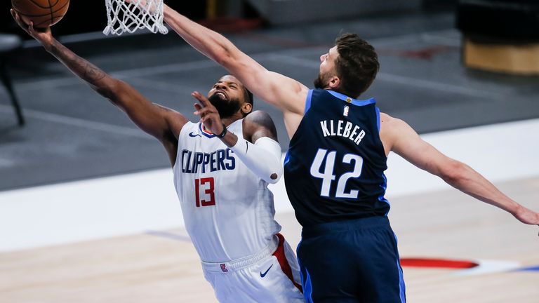 Los Angeles Clippers guard Paul George (13) attempts a layup as Dallas Mavericks forward Maxi Kleber (42) defends during the second half of an NBA basketball game, Monday, March 15, 2021, in Dallas.