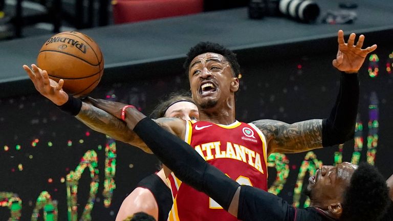 Atlanta Hawks forward John Collins, center top, is fouled by Miami Heat center Bam Adebayo, right, during the second half of an NBA basketball game, Sunday, Feb. 28, 2021, in Miami.