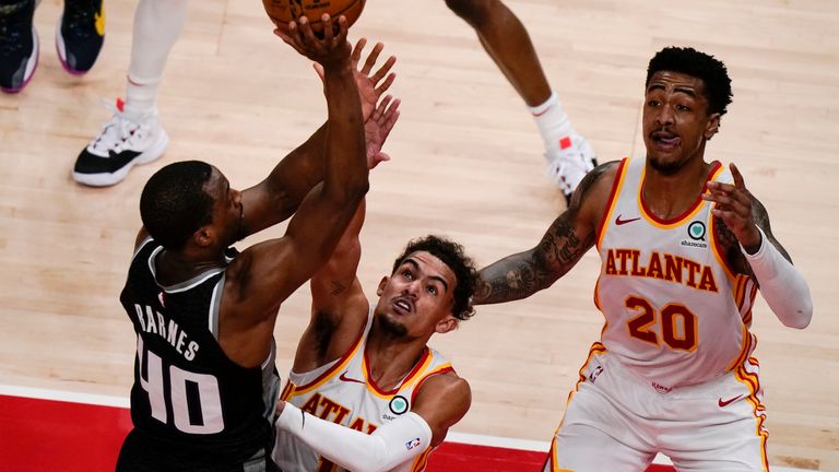 Atlanta Hawks guard Trae Young (11) guards the ball against Sacramento Kings forward Harrison Barnes (40) during the first half of an NBA basketball game on Saturday, March 13, 2021, in Atlanta. 