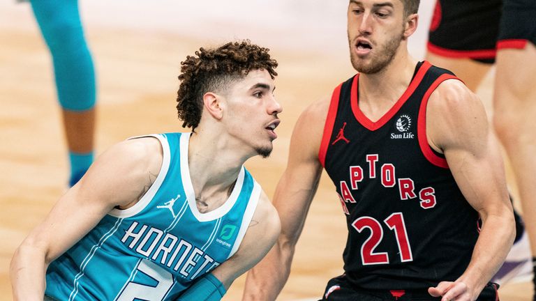 Charlotte Hornets guard LaMelo Ball (2) drives to the basket while guarded by Toronto Raptors guard Matt Thomas (21) during the second half of an NBA basketball game in Charlotte, N.C., Saturday, March 13, 2021.