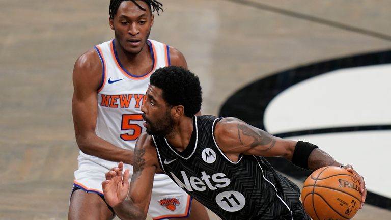Brooklyn Nets&#39; Kyrie Irving (11) drives past New York Knicks&#39; Immanuel Quickley (5) during the first half of an NBA basketball game Monday, March 15, 2021, in New York.