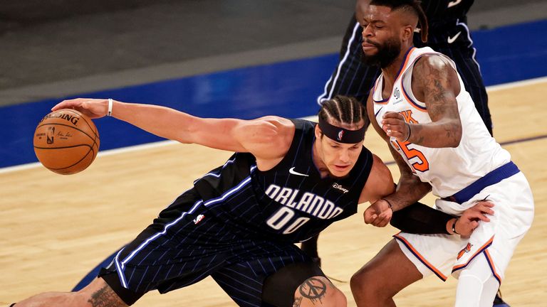 Orlando Magic forward Aaron Gordon (00) is defended by New York Knicks forward Reggie Bullock during the first half of an NBA basketball game Thursday, March 18, 2021, in New York. 