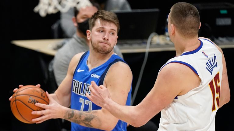 Dallas Mavericks guard Luka Doncic, left, looks to pass the ball as Denver Nuggets center Nikola Jokic defends during the second half of an NBA basketball game Saturday, March 13, 2021, in Denver.