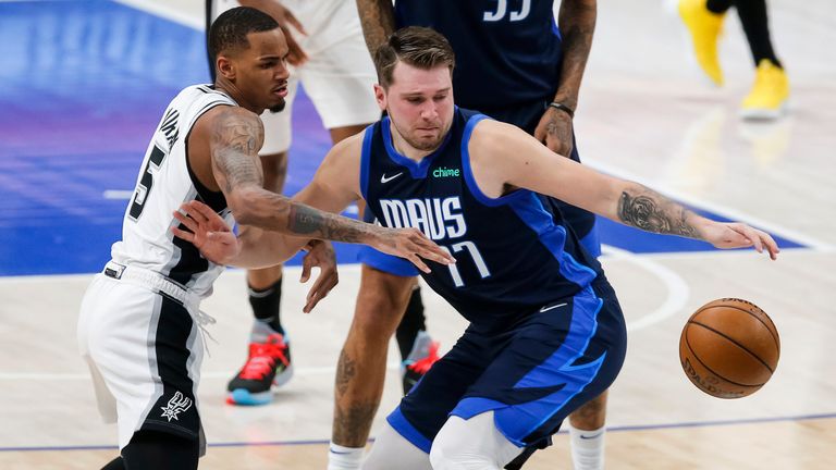 Dallas Mavericks guard Luka Doncic (77) reaches for the ball, while fending off San Antonio Spurs guard Dejounte Murray (5) during the first half of an NBA basketball game Wednesday, March 10, 2021, in Dallas. (AP Photo/Brandon Wade)


