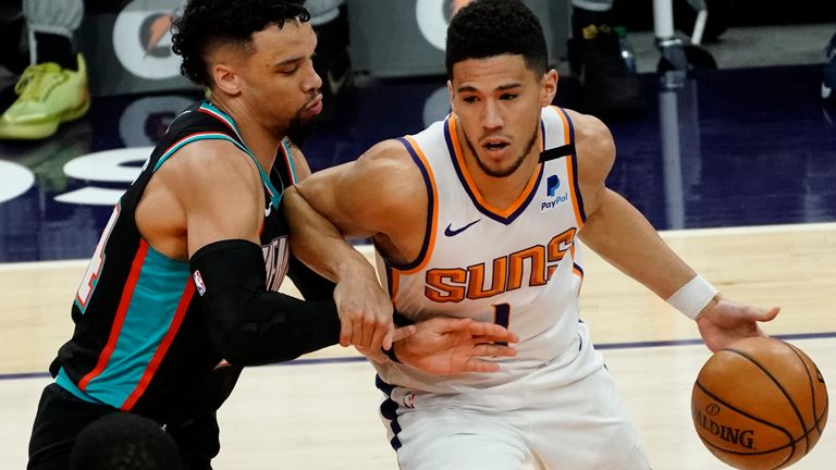 Phoenix Suns guard Devin Booker (1) is pressured by Memphis Grizzlies guard Dillon Brooks during the first half of an NBA basketball game Monday, March 15, 2021, in Phoenix.