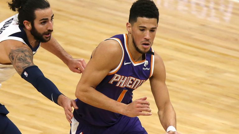 Phoenix Suns' Devin Booker (1) drives the ball past Minnesota Timberwolves' Ricky Rubio (9) in the first half of an NBA basketball game, Sunday, Feb. 28, 2021, in Minneapolis.
