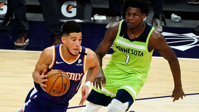 Phoenix Suns guard Devin Booker drives on Minnesota Timberwolves forward Anthony Edwards (1) during the second half of an NBA basketball game Thursday, March 18, 2021, in Phoenix. Minnesota won 123-119.